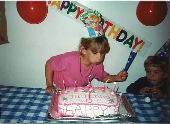 A little girl blowing out candles on her birthday cake
