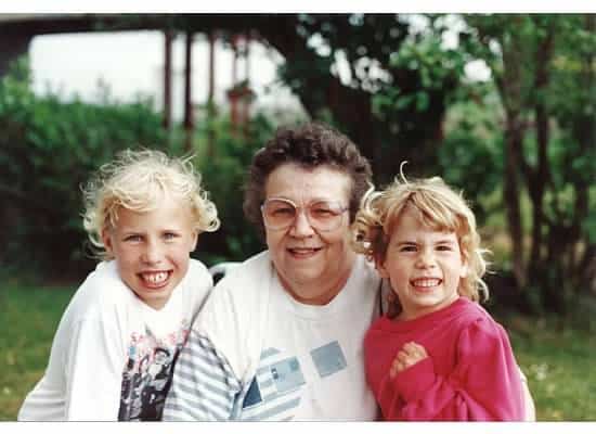 A grandmother posing with two granddaughters outside