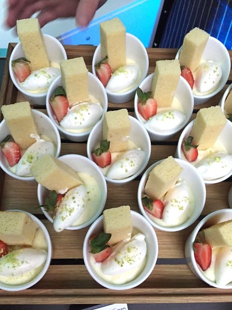 Overhead view of dessert cups with strawberries, cake, and cream