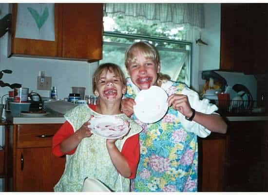 Two little girls with empty plates and frosting on their faces