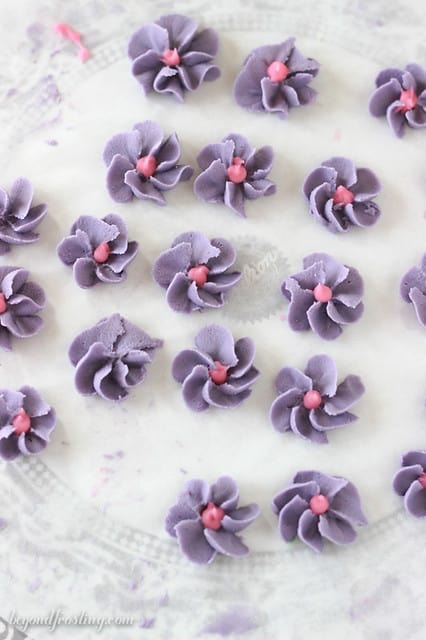 Overhead view of purple frosting flowers with a pink center