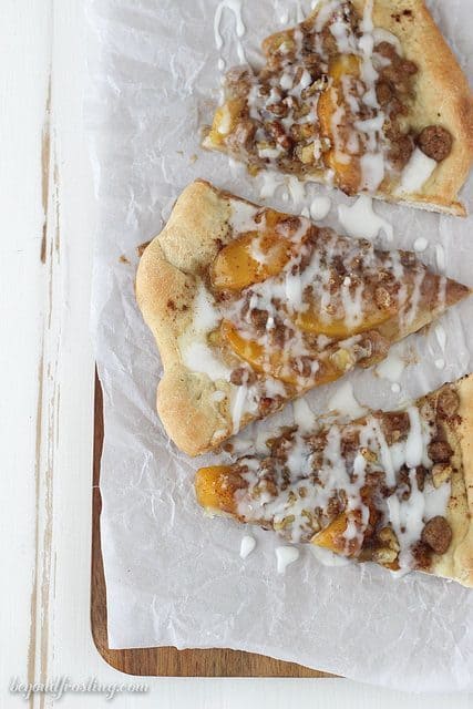 This Peach Streusel Pizza is a cinnamon and sugar loaded pizza dough covered in peaches, walnuts and a vanilla glaze.