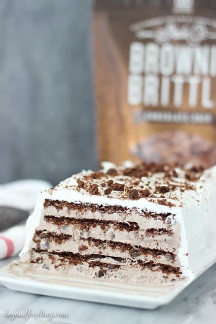 Side view of Brownie Brittle Icebox Cake on a platter showing layers of chocolate and cream