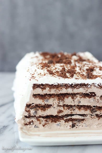 Side view of Brownie Brittle Icebox Cake on a platter showing layers of chocolate and cream