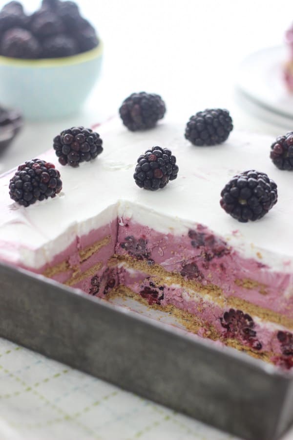 A vintage baking pan has a a layered frozen dessert with graham crackers and a no-churn blackberry ice cream