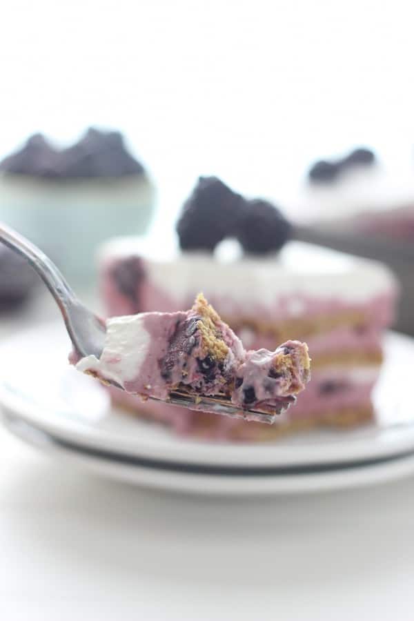 A silver fork with a bite of blackberry icebox cake