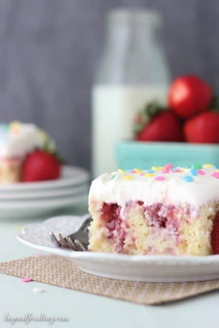 This Strawberry Cheesecake Poke cake is similar to a tres leches cake. The vanilla cake is filled with sweetened condensed milk and it’s topped with a fresh strawberry sauce and cream cheese whipped cream