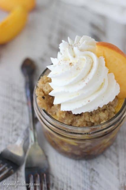 Peach Maple Walnut Crisps with Champagne Whipped Cream. These easy peach crisp are baked in jars, making them perfect to bring to a party.