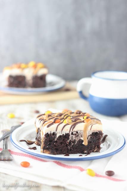 This rich chocolate poke cake is loaded with Reese’s, smothered in chocolate pudding and topped with peanut butter whipped cream and drizzled with peanut butter and chocolate.