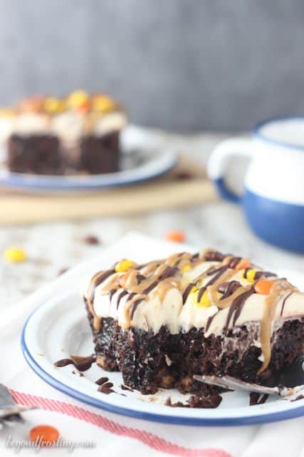 This rich chocolate poke cake is loaded with Reese’s, smothered in chocolate pudding and topped with peanut butter whipped cream and drizzled with peanut butter and chocolate.