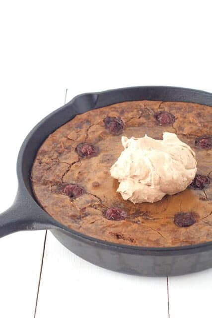 Dig into this deep dish Black Forest Skillet Brownie filled with cherries and topped with chocolate whipped cream. 