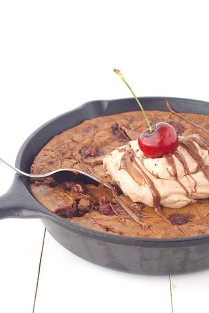 Dig into this deep dish Black Forest Skillet Brownie filled with cherries and topped with chocolate whipped cream. 