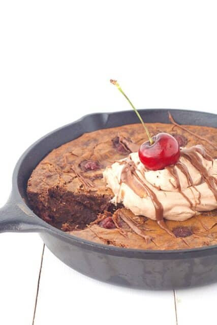 Dig into this deep dish Black Forest Skillet Brownie filled with cherries and topped with chocolate whipped cream. 
