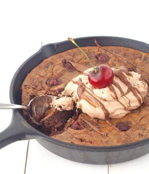 Rich chocolate brownie filled with cherries and topped with chocolate whipped gream