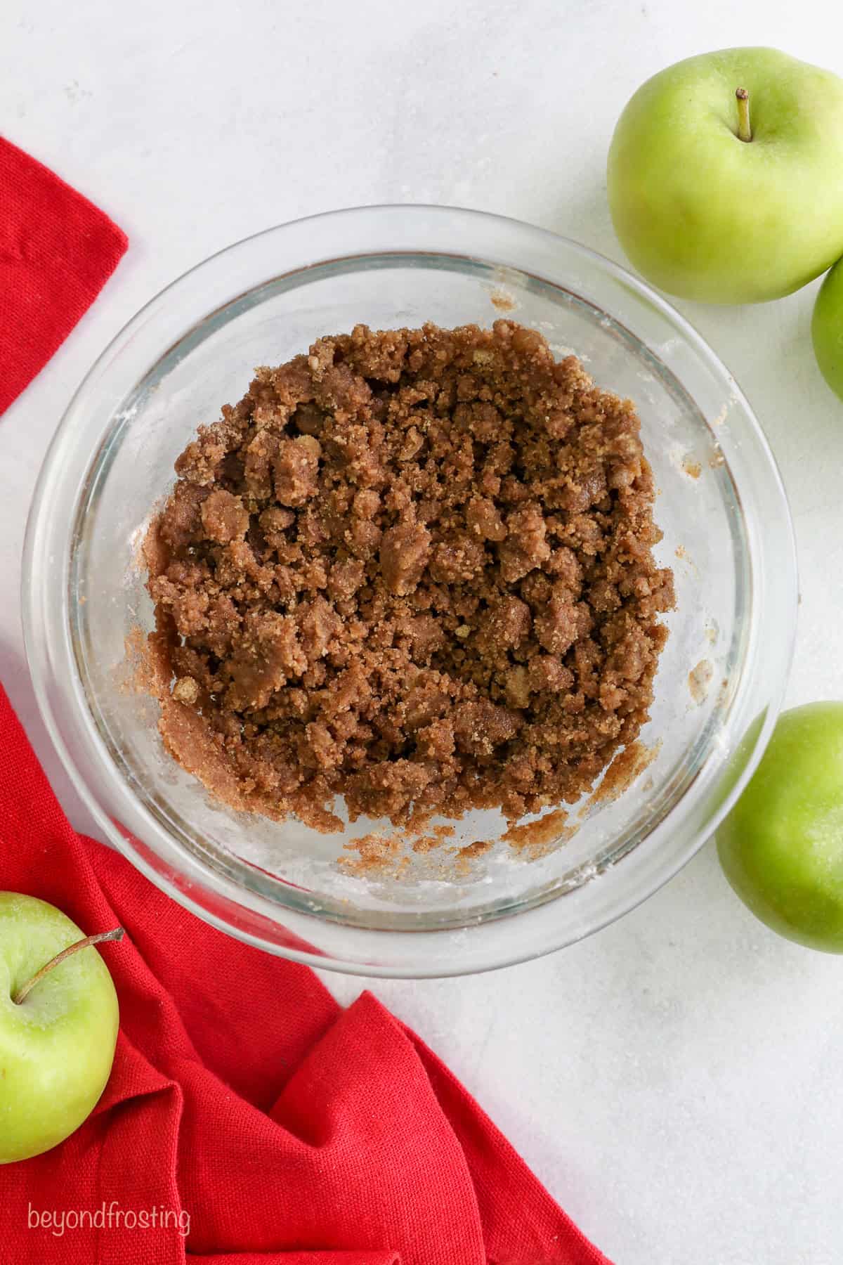 Overhead view of cinnamon streusel in a glass bowl.