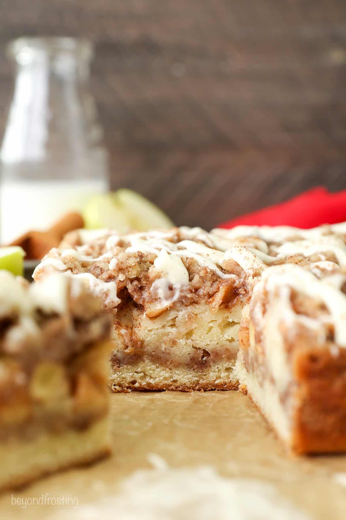 Close up side view of apple coffee cake with a slice missing.