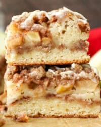 Side view of a two apple coffee cake slices stacked on top of one another.