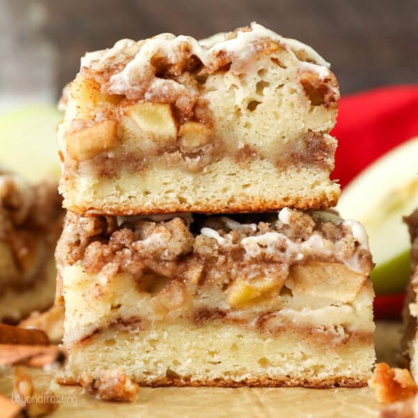 Side view of a two apple coffee cake slices stacked on top of one another.