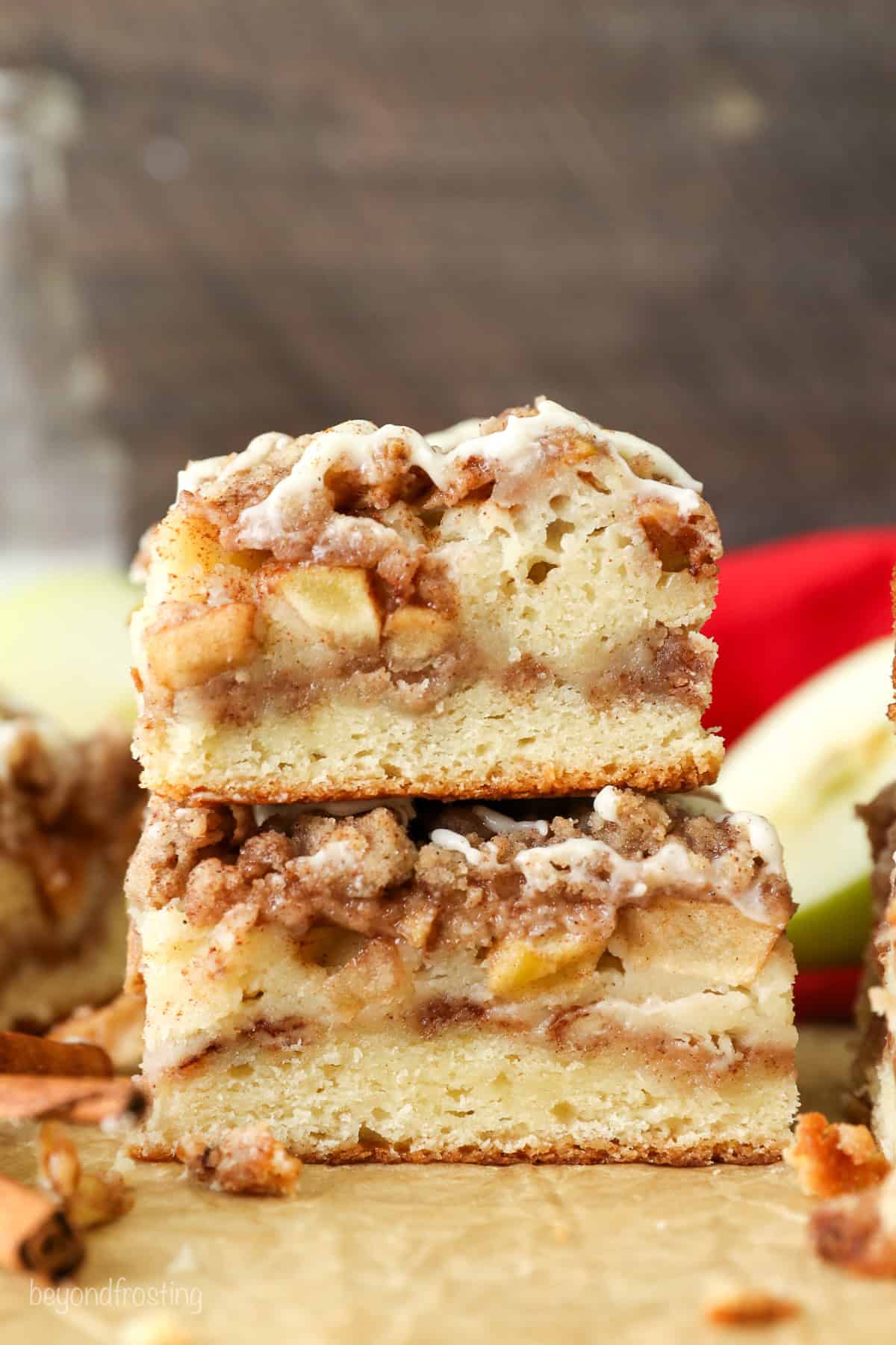 Side view of a two apple coffee cake slices stacked on top of one another.