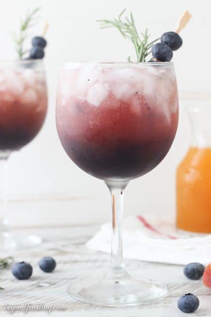 This Blueberry Peach Spritzer is the best summer cocktail!! First I prepared a simple, fresh blueberry syrup which is combined with peach juice concentrate and topped off with prosecco. Now if you are looking for a virgin drink, this also works great with a little bit of seltzer as well. 