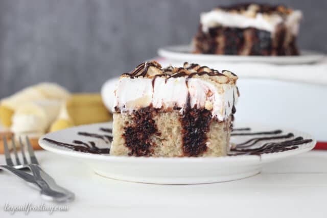 This Chocolate Banana Cream Pie Poke Cake is a moist banana cake filled with chocolate pudding and topped with sliced bananas and whipped cream. It is topped with crushed Nilla Wafers and drizzled with fudge. 