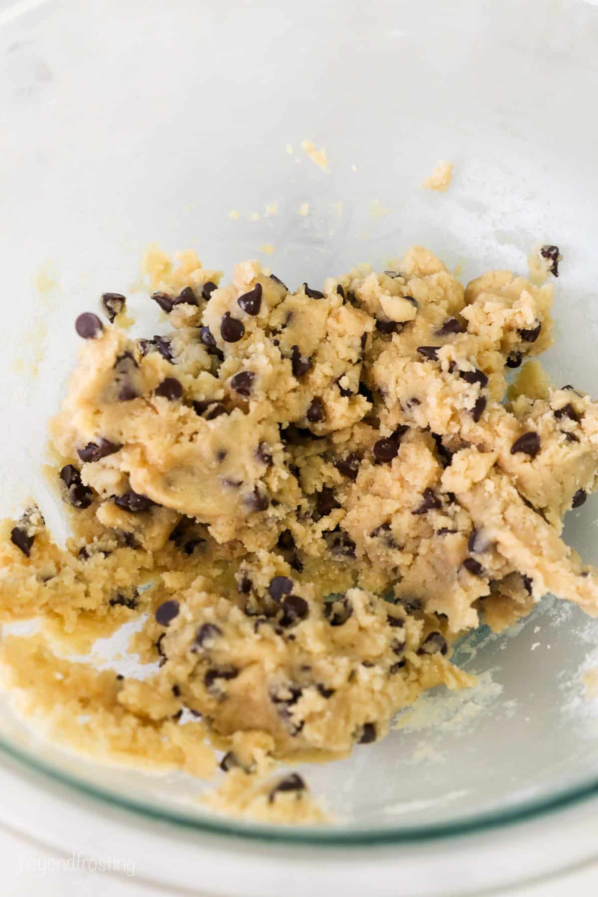 Edible chocolate chip cookie dough in a glass bowl.