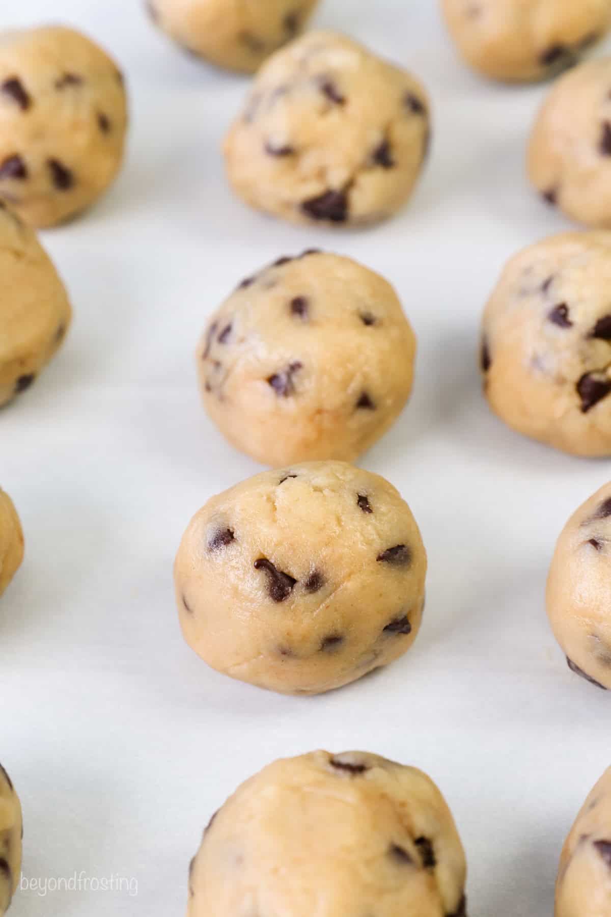 Rows of chocolate chip cookie dough balls.