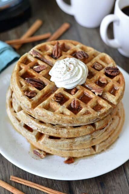 These waffles are loaded with cinnamon and topped with pecans and maple syrup. 