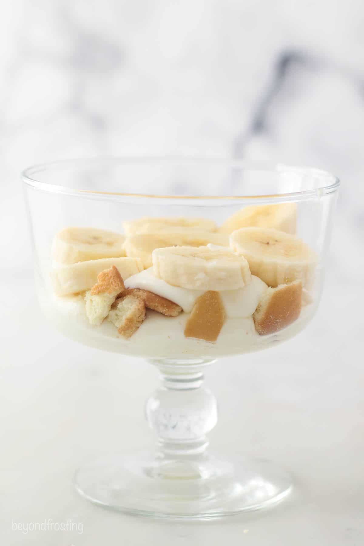 This copycat Magnolia Bakery banana pudding recipe has sliced bananas and softened Nilla Wafers layered with light, fluffy vanilla pudding. Banana slices on top of cookie pieces and mousse