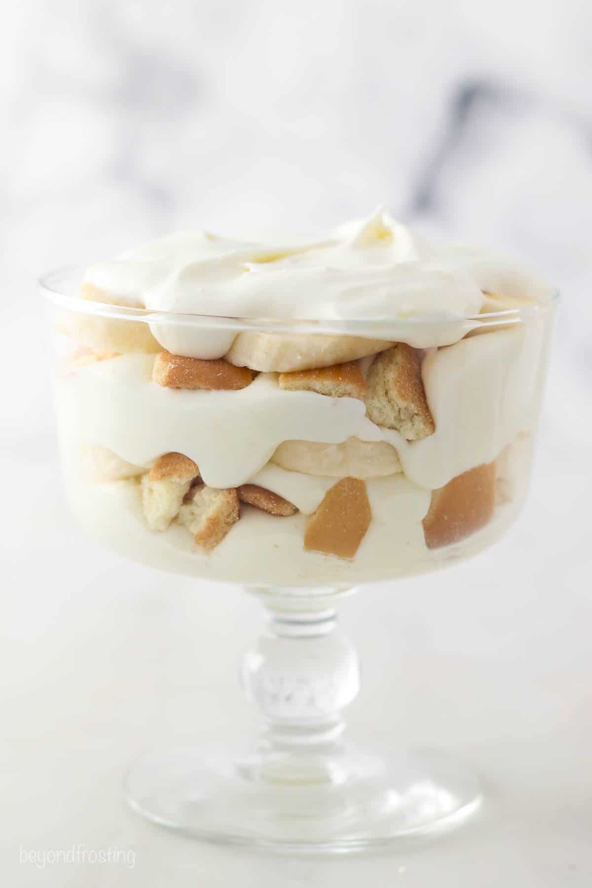 This copycat Magnolia Bakery banana pudding recipe has sliced bananas and softened Nilla Wafers layered with light, fluffy vanilla pudding. Layers of banana pudding in a glass trifle bowl