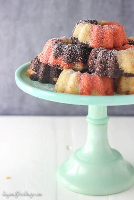 These Mini Neapolitan Bundt Cakes are a blend of vanilla, chocolate and strawberry cake baked together to create the most delicious mini cakes. Finish them off with a dusting of powder sugar. 