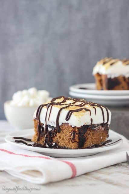 This Pumpkin S’mores Poke Cake is a pumpkin cake with a chocolate crust. It filled with chocolate pudding and topped with marshmallow whipped cream.