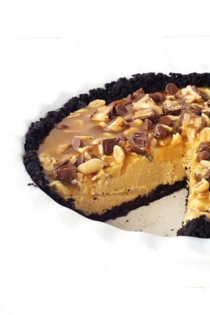 This Snicker Peanut Butter Oreo Pie will make you swoon. An Oreo crust is filled with smooth peanut butter filling and topped with Snickers, peanuts, caramel sauce and chocolate chips. 