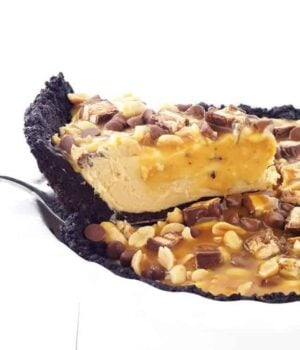This Snicker Peanut Butter Oreo Pie will make you swoon. An Oreo crust is filled with smooth peanut butter filling and topped with Snickers, peanuts, caramel sauce and chocolate chips.