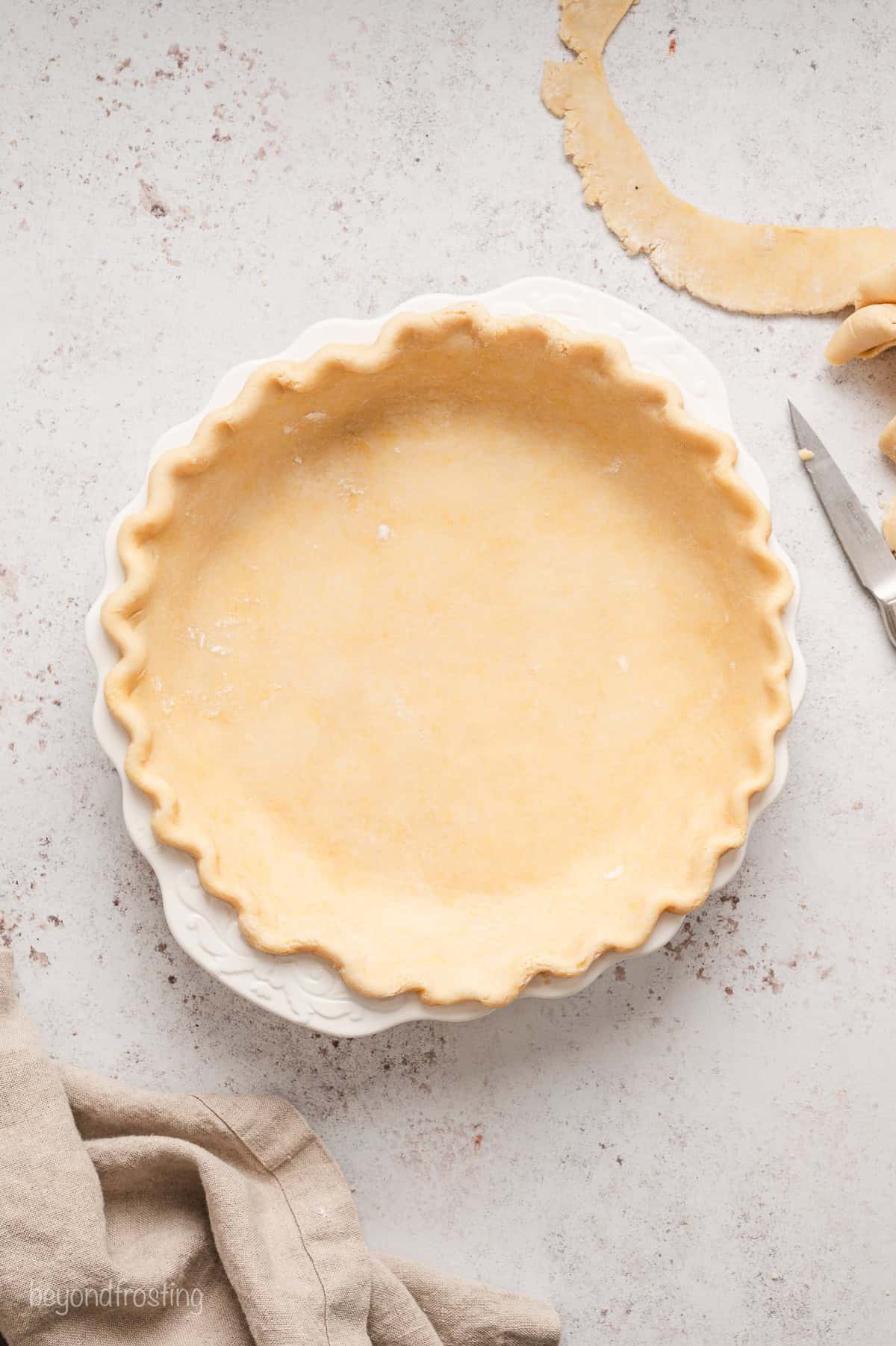 Prepared pie crust in a ceramic pie plate.