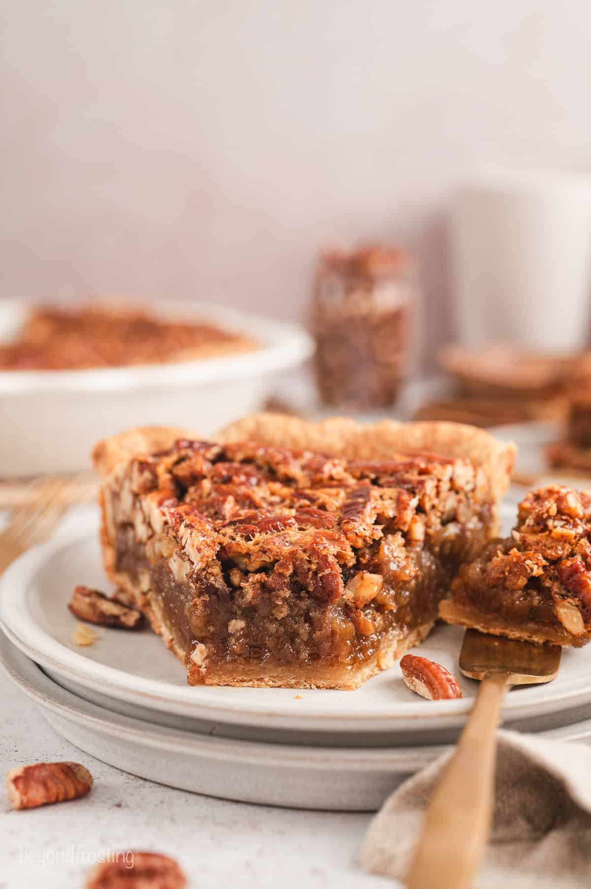 A slice of pecan pie with a forkful missing from the end, on a plate.