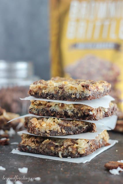 Gooey Brownie Brittle Toffee Seven Layer Bars. The Brownie Brittle crust is layered with coconut, toffee, chocolate and walnuts.