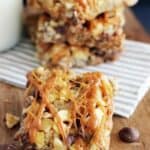 Chunky Monkey Magic Bars with layers of shredded coconut, walnuts, sweetened condensed milk, and a caramel drizzle topping.