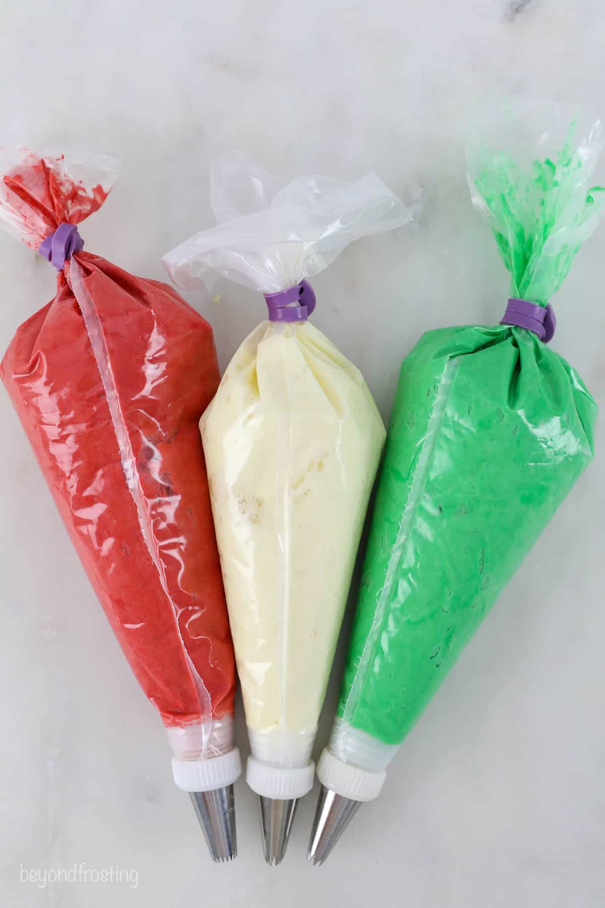 Three piping bags with buttercream frosting
