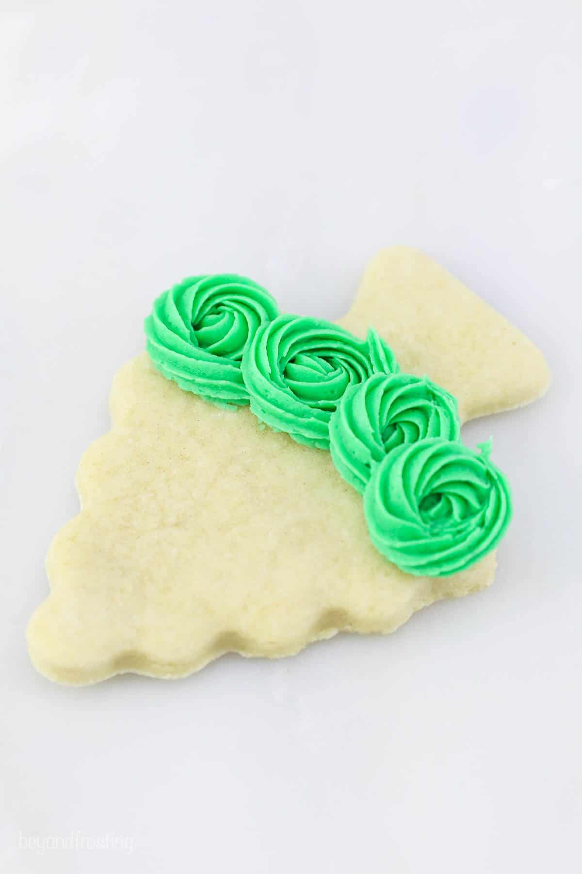 Rosettes piped on a sugar cookie christmas tree