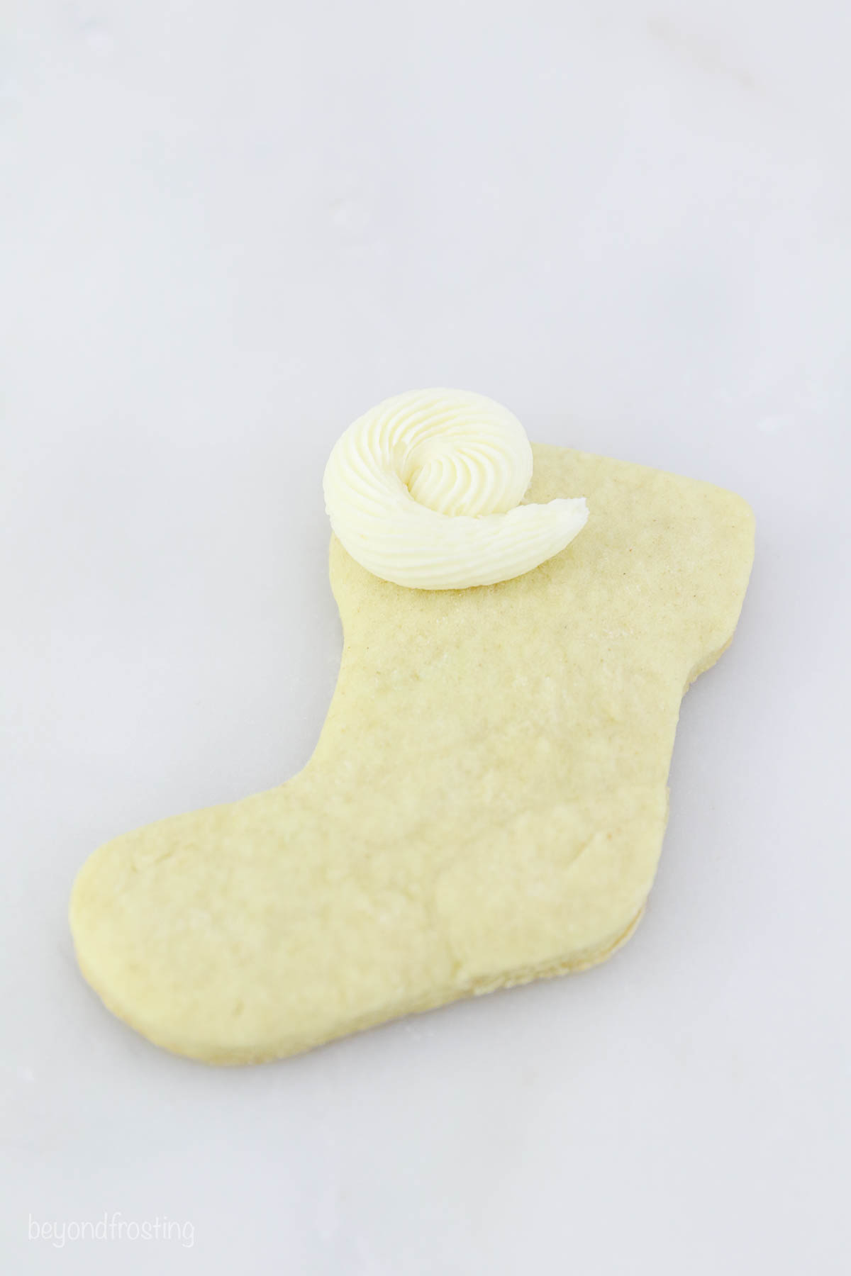 A stocking sugar cookie with a white rosette