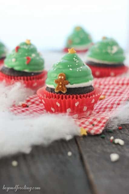 These adorable cupcakes are topped with a marshmallow frosting and dipped in green candy melts, decorated like a Christmas tree.