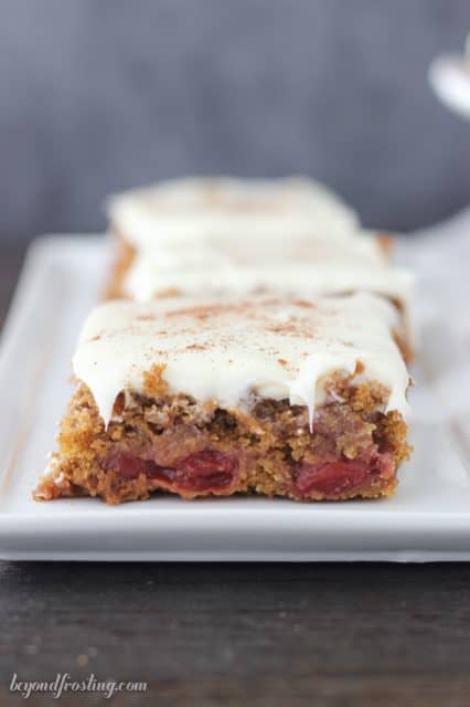 Perfectly perfect gingerbread cake bars with cherry pie filling and vanilla frosting.