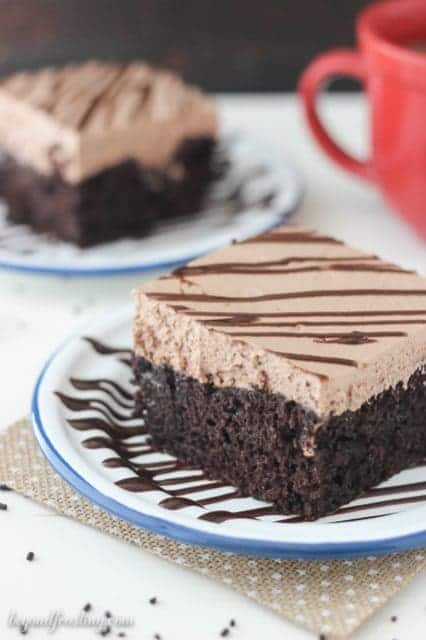 This Hot Chocolate Poke Cake is a rich chocolate cake with hot fudge glaze and hot chocolate whipped cream.