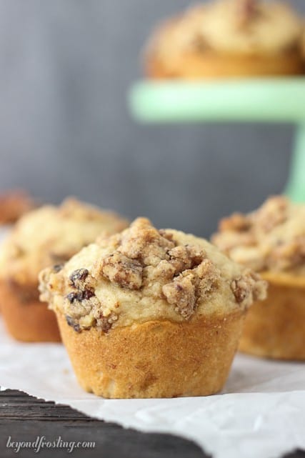 A close-up shot of a fluffy banana breakfast muffin with a maple pecan streusel on top