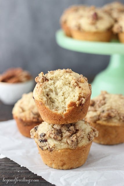 A stack of two maple pecan muffins with a large bite taken out of the top one