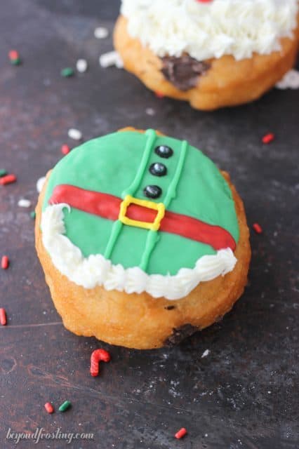 These Santa and Elves Donuts are made with Pillsbury Grands Biscuits, filled with a chocolate buttercream and decorated santa heads and elves.