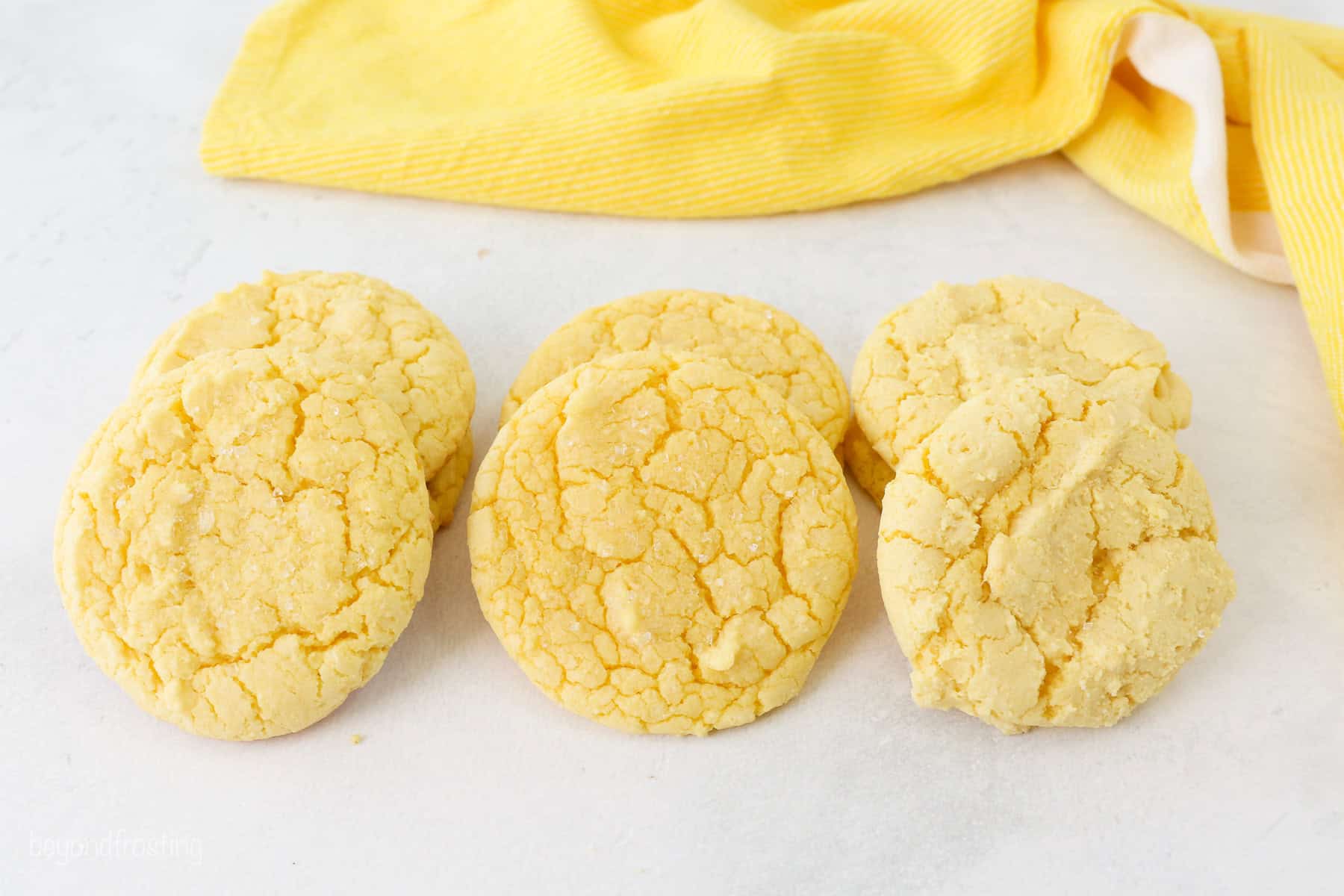 Lemon cake mix cookies shown side by side, demonstrating the differences in baking times on the texture of the cookies.