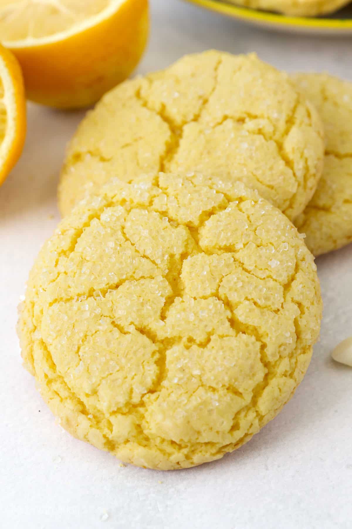 Close up of lemon cake mix cookies on a white surface.