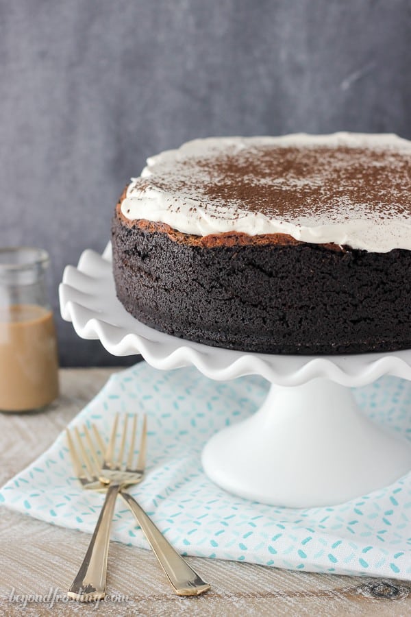 A Baileys chocolate cheesecake on a white ruffled edge cake stand